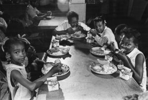 Children sit around a table eating breakfast
