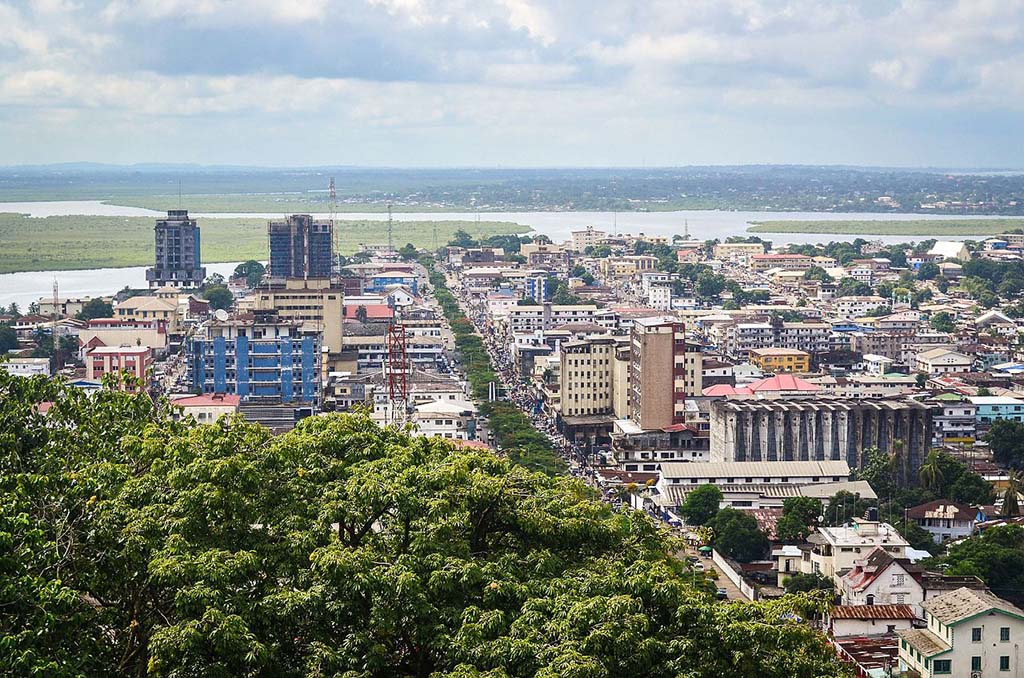 An image of Monrovia, Liberia, with green trees and city buildings