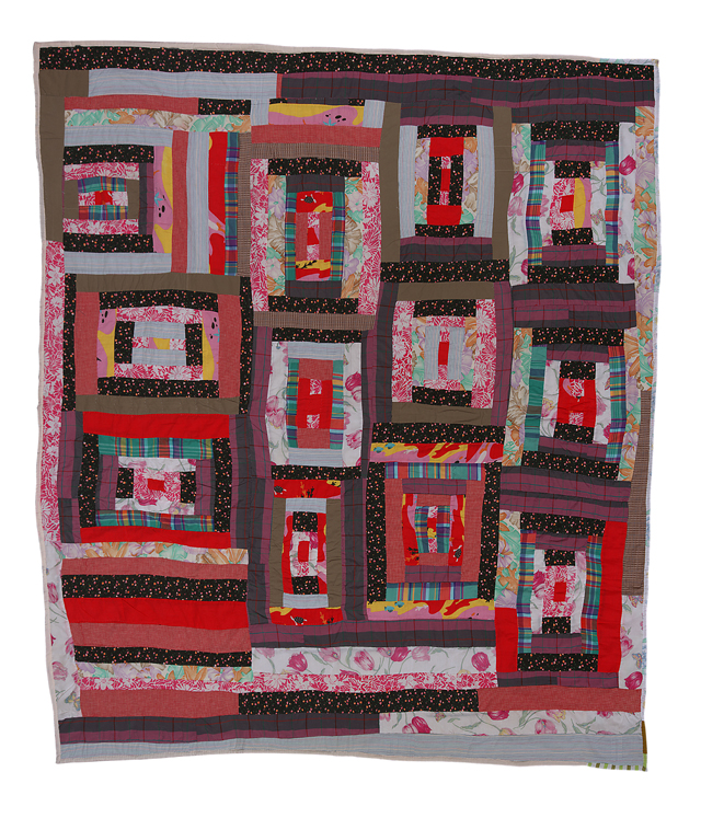 A brightly patterned quilt with a series of rectangles in stripes of mostly red, pink, and brown.