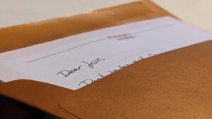 A gold envelope with a letter peeking out that says "Dear Josie."